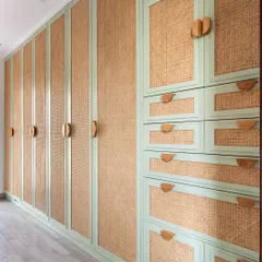 The wardrobe doors are finished with a beautiful mint green paint and natural rattan, adding texture and a soft pop of color. The custom wooden handles are easy for little hands to use.