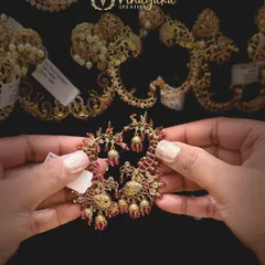 A stunning pair of ear cuffs in a ruby-red color. The intricate design with delicate bead drops makes them a perfect statement piece for weddings and parties.