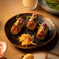 A closer look at one of my signature small plates. The textures of the filling, the soft bun, and the crisp garnish of fried ginger create a complete, multi-layered bite.