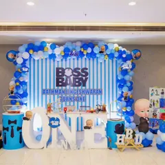 This Boss Baby setup for Linga's first birthday was all about the details. We used a blue and white striped backdrop, a full balloon arch with character balloons, and a custom "ONE" table, making sure the little boss had a memorable celebration.