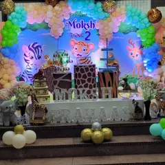 A full view of the stage for a "Wild Two" jungle party. The setup includes a custom backdrop with a tiger cub, animal print pedestals, and 3D letters for the child's name.