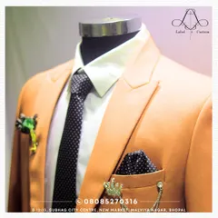 A close-up on how accessories can crown your outfit. This image shows a polka dot pocket square and a crown-shaped lapel pin, adding a touch of majesty and personal flair to a simple suit jacket.