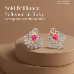 Bold brilliance softened in ruby. These statement earrings feature a central ruby surrounded by a halo of intricate diamond work, designed to own the moment and capture attention.