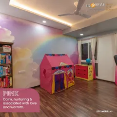 A dreamy kid's room with a beautiful rainbow and cloud mural. The soft pink tent creates a cozy reading nook, and the colorful furniture adds to the cheerful and nurturing atmosphere.