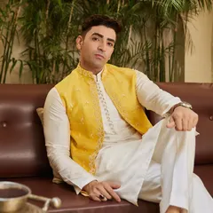 A relaxed pose showcasing the comfort and style of the Haldi outfit. The fine embroidery on the jacket adds a touch of bespoke luxury.
