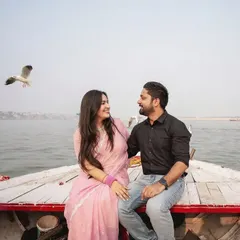 Another beautiful angle from the boat photoshoot in Banaras. This image captures the couple's happy interaction with the scenic river and birds in the background.