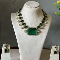 This single-layer Victorian necklace with a large rectangular green stone is a statement piece. It comes with matching earrings and is perfect for a minimalist but bold look.