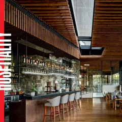 The bar at the Radisson Resort showcases the project's material palette. A stone feature wall, wooden ceiling, and copper-toned bar create a warm, tactile environment, while large glass windows maintain a constant connection to the outdoors.