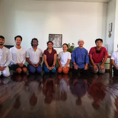 Participants kneeling in Vajrasana after a session. The polished floor reflects the stillness in the room, a common experience after the harmonizing effects of the Surya Kriya practice.