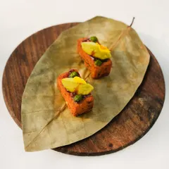 Kothimbir vadi, a classic Maharashtrian snack, is presented on a dried leaf. This small bite is packed with flavour, showcasing how we honour tradition while adding our own inventive touch.
