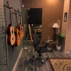 A look down the hallway of our studio, with a line of acoustic guitars ready for students to use during their lessons.