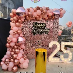 We created this stunning photo corner for a 25th birthday on a rooftop. The rose gold sequin wall, matching balloon arch, and large light-up '25' provided the perfect backdrop for party pictures.