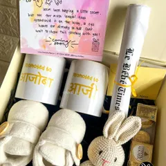 Announcing a pregnancy is pure magic. I designed this special reveal hamper for a client to surprise the grandparents-to-be with personalized mugs, tiny baby booties, and a custom 'Le Bébé Times' announcement scroll.