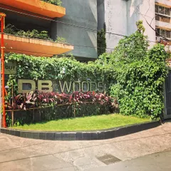 Green walls don't always require a complex vertical garden system. For the entrance of DB Woods, we used climbing creepers to create a natural, wild green wall that beautifully frames the building's signage.
