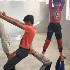 Teamwork in action. This multi-person pose requires every child to play their part, supporting each other to create a stable and impressive acrobatic structure.