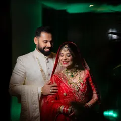 A beautifully lit portrait of a couple sharing a happy moment, with the groom's arm around his bride.