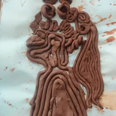 A beautiful silhouette filled with intricate coils of clay, creating a sense of flowing hair. This piece showcases a wonderful use of texture and pattern.