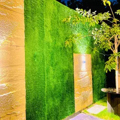 This vertical turf wall is installed between stone-clad panels. The addition of spotlights creates beautiful shadows and highlights at night, turning a plain wall into a sophisticated design feature.