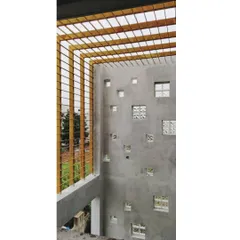 A view of a backyard wall under construction. This design features a pattern of square niches with glass blocks and an overhead MS pergola, which will eventually support climbing plants.
