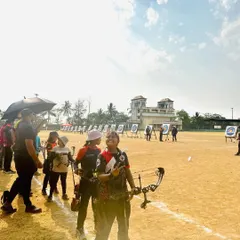 An archer gets ready on the shooting line at the Drona Cup, with targets set up in the distance.