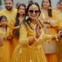 A bride dances with abandon at her Haldi ceremony, surrounded by friends and family in a sea of yellow.