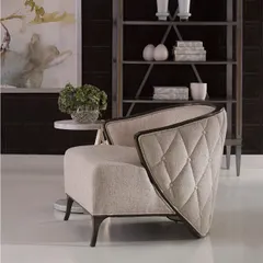This graceful lounge chair features curving, wing-like arms that are buttoned and tufted on the outside. Trimmed in dark wood, the chair's unique silhouette makes it a sculptural and comfortable addition to any room.