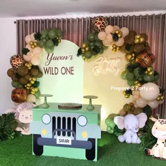 This jungle theme features a custom safari jeep cake table and dual backdrops. The balloon garland includes animal print balloons and tropical leaves, creating an adventurous feel for a "Wild One" party.