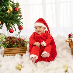 The cutest Santa in town, sitting happily by the Christmas tree. This festive sitter session is perfect for capturing your baby's joyful spirit during the holidays.