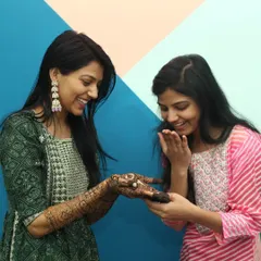 Another candid moment from the same Mehandi event, showing the genuine surprise and delight between friends. These unposed shots tell the real story of the celebration.