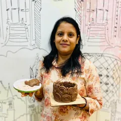 A proud student displays the intricate coiled pot she created in my pottery workshop, a perfect example of what you can make with hand-building techniques.