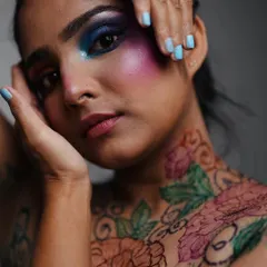 A stunning portrait from a creative photoshoot where I used multi colored henna to create a bold floral design across the model's neck and chest, complementing the dramatic makeup.