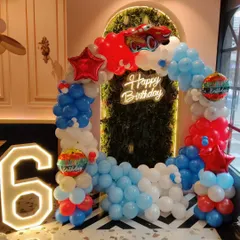 For a fan of Disney's Cars, this Lightning McQueen themed party is a winner. The setup includes a balloon arch in red, white, and blue, a large marquee number '6', a neon birthday sign, and a prominent Lightning McQueen foil balloon at the top.