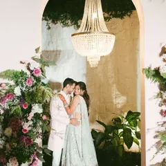Framed by a floral arch and a magnificent chandelier, Avi and Devika share a quiet moment during their engagement celebration. I love blending grand decor with genuine emotion to create portraits that feel both opulent and authentic.