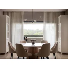 The dining room in the Warm Minimal home was designed to frame the gorgeous view of the forests. A round marble-topped table and upholstered chairs create an intimate and elegant setting.
