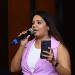 A close-up shot of me hosting the Infosys event. I often use my phone for interactive polls or to manage event cues, ensuring a seamless and modern hosting experience.