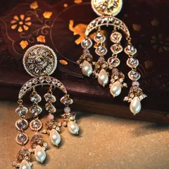 A pair of classic chandbali earrings, featuring a crescent design with cascading polki and pearl drops. Timeless, elegant, and perfect for any celebration.