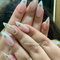 A celestial-themed design on long stiletto nails. This look features a soft ombre base, gold chrome outlines, and hand-painted gold stars for a magical, sparkling finish.