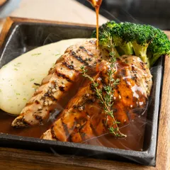A sizzling steak platter with gravy being poured over it. We capture the steam and sizzle to create a multi-sensory experience for the viewer.