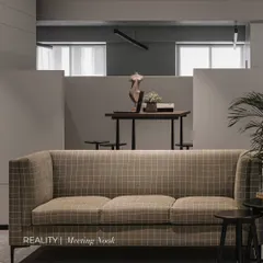 From render to reality. This is the final meeting nook, closely mirroring the render but with added layers of styling and texture, like the checkered couch and potted plant, which bring the space to life.