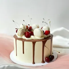A classic combination of chocolate, cherry, and vanilla. This drip cake is generously topped with fresh cherries and macarons, perfect for any celebration.