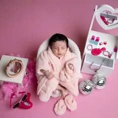 A pampering spa day for this little beauty. Dressed in a fluffy pink bathrobe, she's surrounded by a miniature vanity, disco balls, and other fun, girly props.