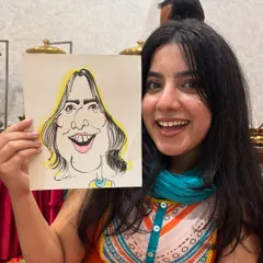 Her vibrant personality shines through in this picture, holding her equally lively caricature.