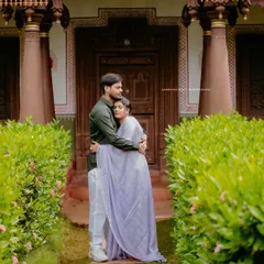 An intimate embrace between a couple outside a traditional home, capturing the blend of romance and cultural heritage.