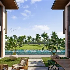 The view from within the villa's courtyard, looking out over the pool to the lush green paddy fields beyond. This perfectly framed view is a key element of the design, connecting the home to its beautiful surroundings.