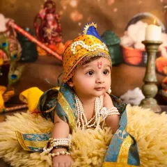 A baby boy dressed as Little Krishna, lying on a fur rug in a beautifully detailed set with traditional Indian decor, peacock feathers, and clay pots.