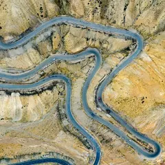 The roads in Ladakh are like arteries on the land, each turn telling a story of a journey. This top-down shot of the winding mountain roads shows the beautiful, abstract patterns nature and man create together. It's a perspective you can only truly appreciate from the sky.