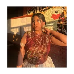 A closer look at the draped top and the creative makeup for this fusion look. The styling extends to the face gems and armlet, tying the whole theme together.