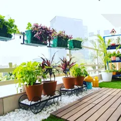 A closer look at the balcony garden, showing the creative use of planters on stands and hanging from the railing. We use white pebbles as a decorative ground cover to complete the look.