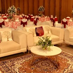 A comfortable lounge area for guests, with plush cream sofas, cushions featuring the 'tree of life' motif, and a beautiful Persian rug.
