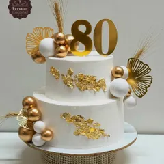 This two-tier cake was designed for a grand 80th birthday celebration. I used a clean white whipped cream frosting as the canvas for elegant gold leaf, decorative spheres, and a bold topper, creating a sophisticated and memorable design.